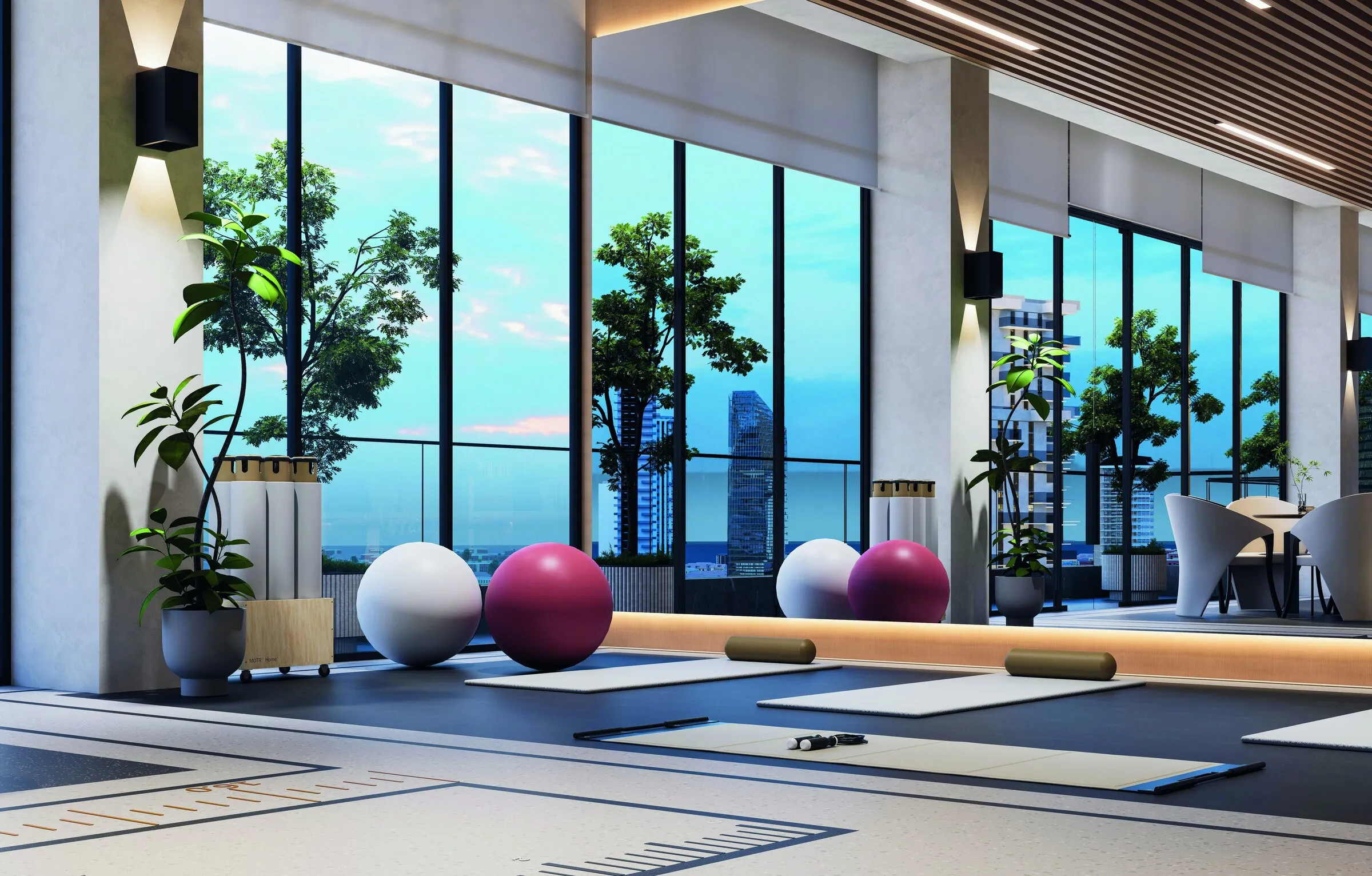 Yoga room with mats and exercise balls in front of tall windows